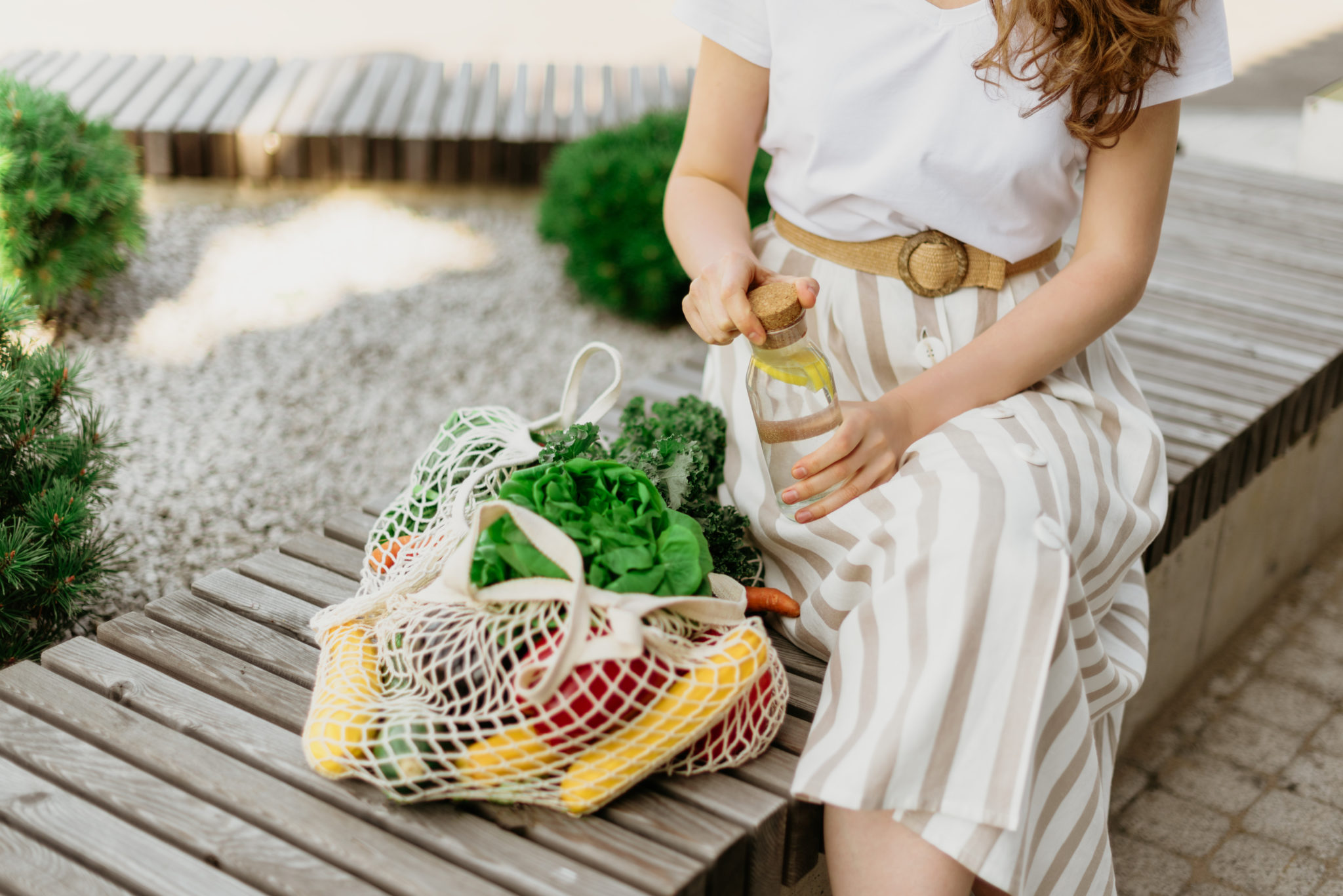 Image of conscious shopper with mesh bag of vegetables and eco-products 