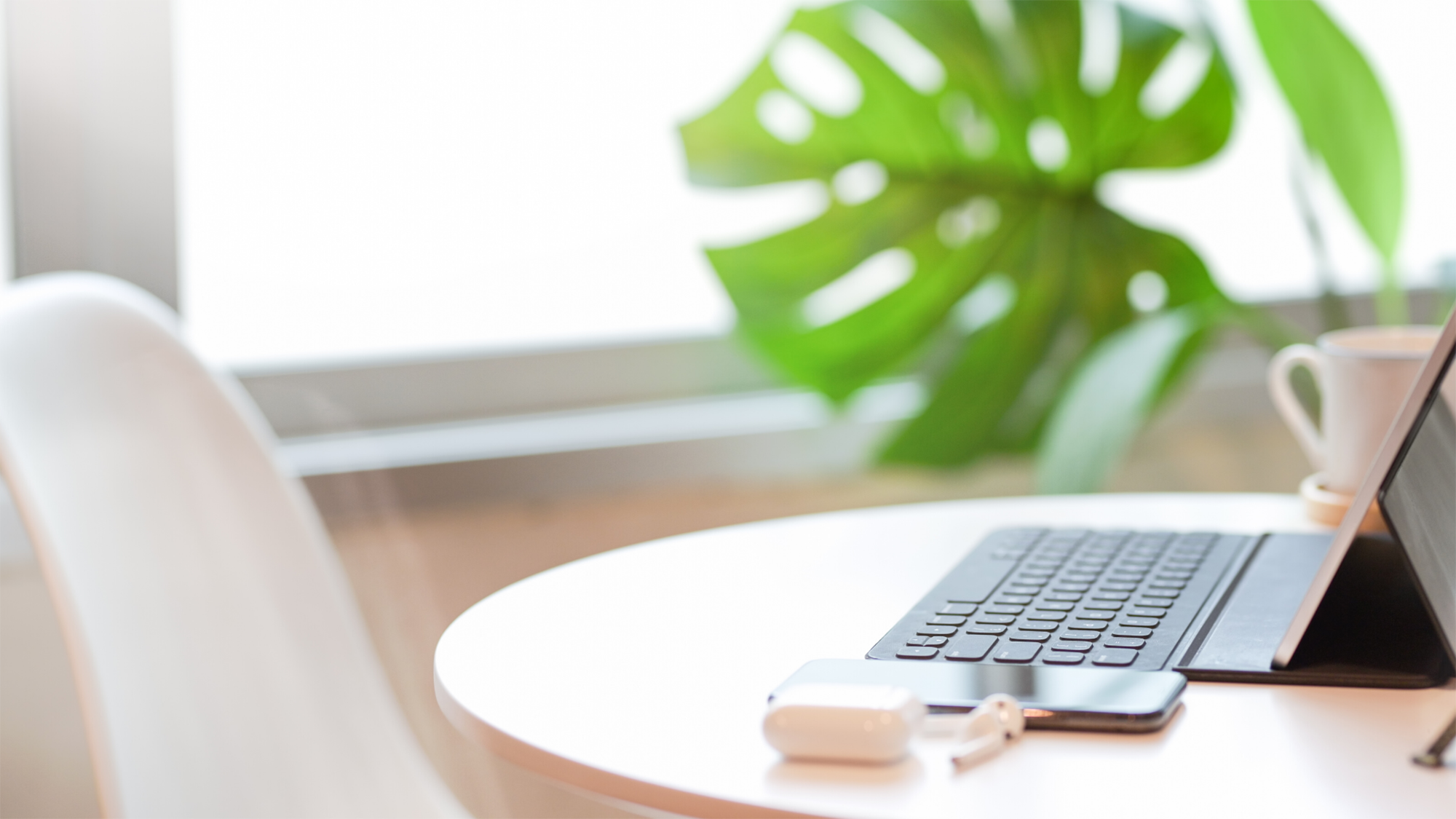 Image of home office with desk, chair, laptop and plant