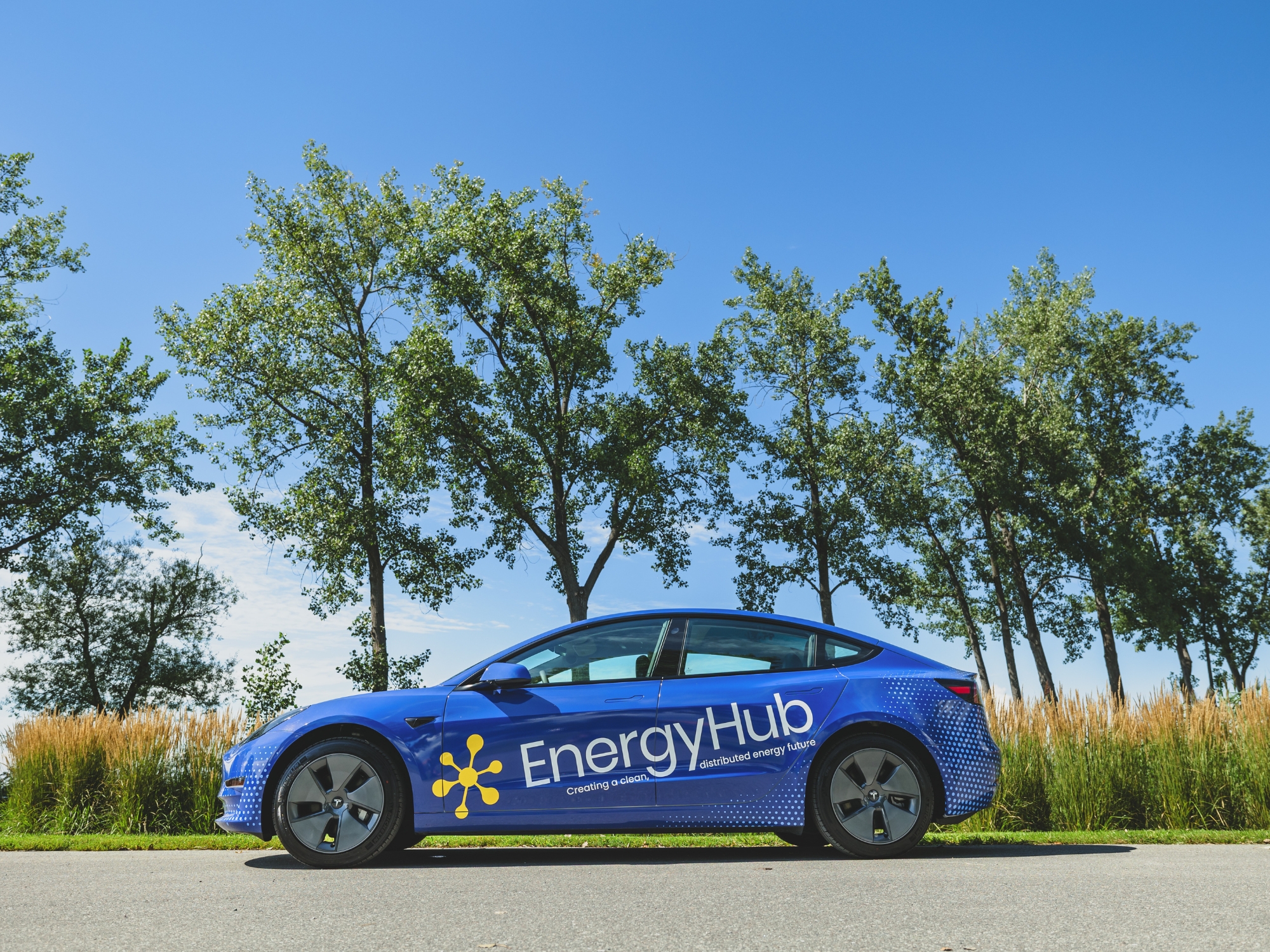 Full left side view of Tesla car wrap designed by Sonja Meyer, featuring EnergyHub logo across both doors.