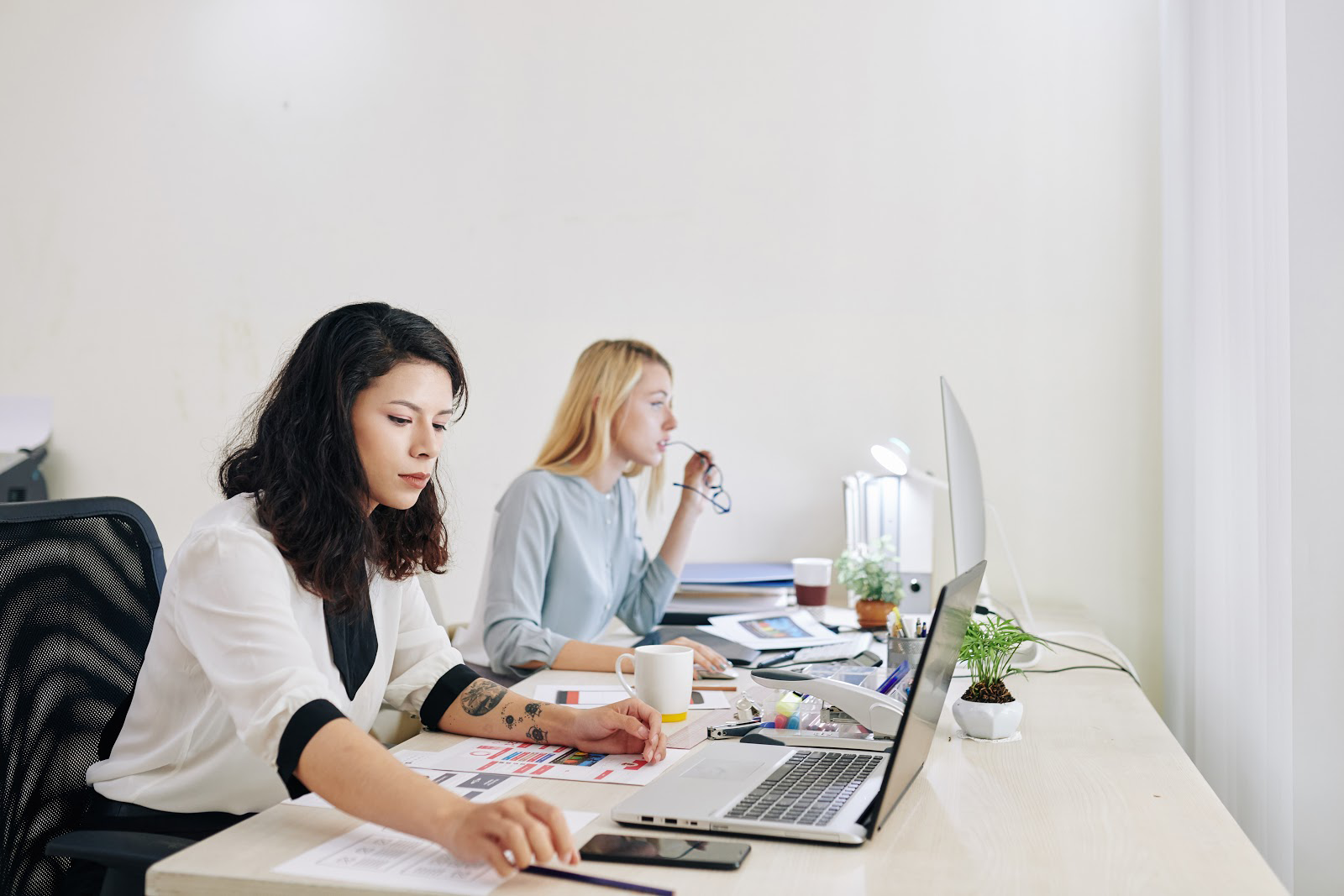 Two professional women working on laptops