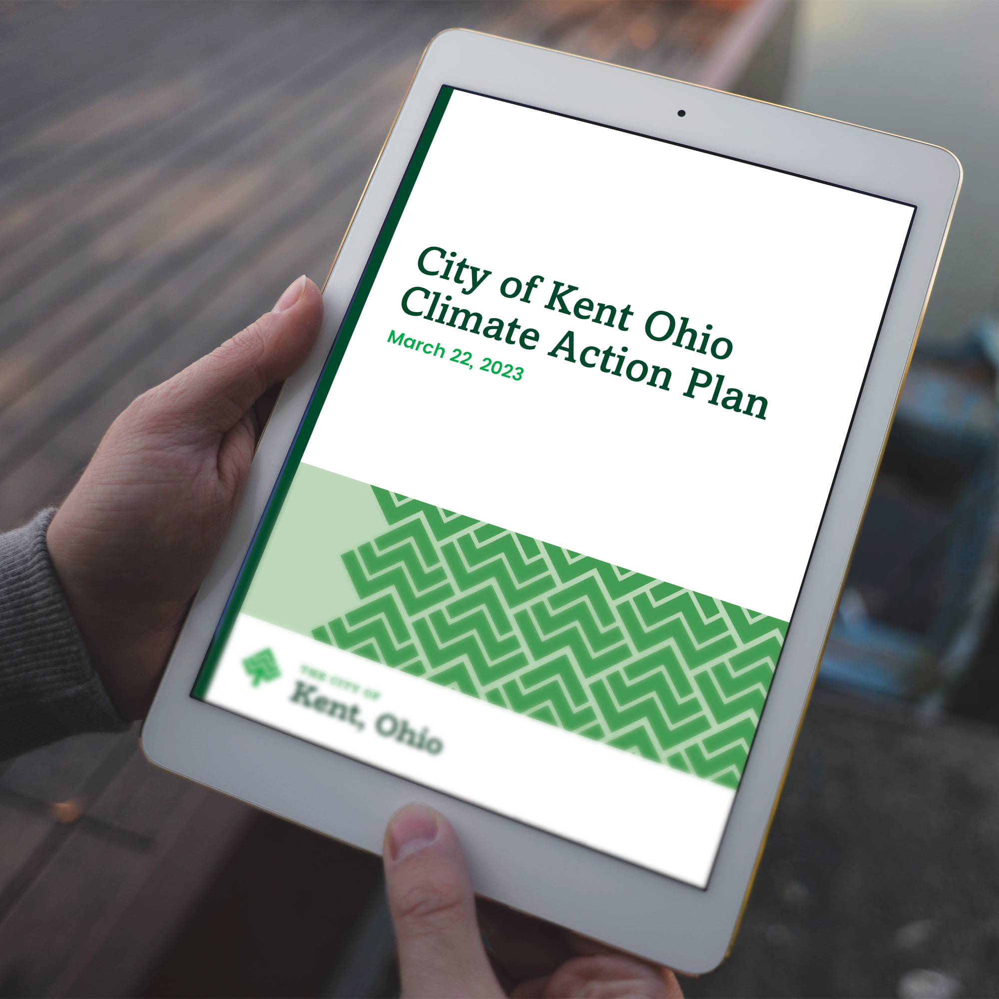 Tablet displaying the City of Kent, Ohio's Climate Action Plan cover, a report developed by KERAMIDA and designed by Ethical Design Co. in PowerPoint.