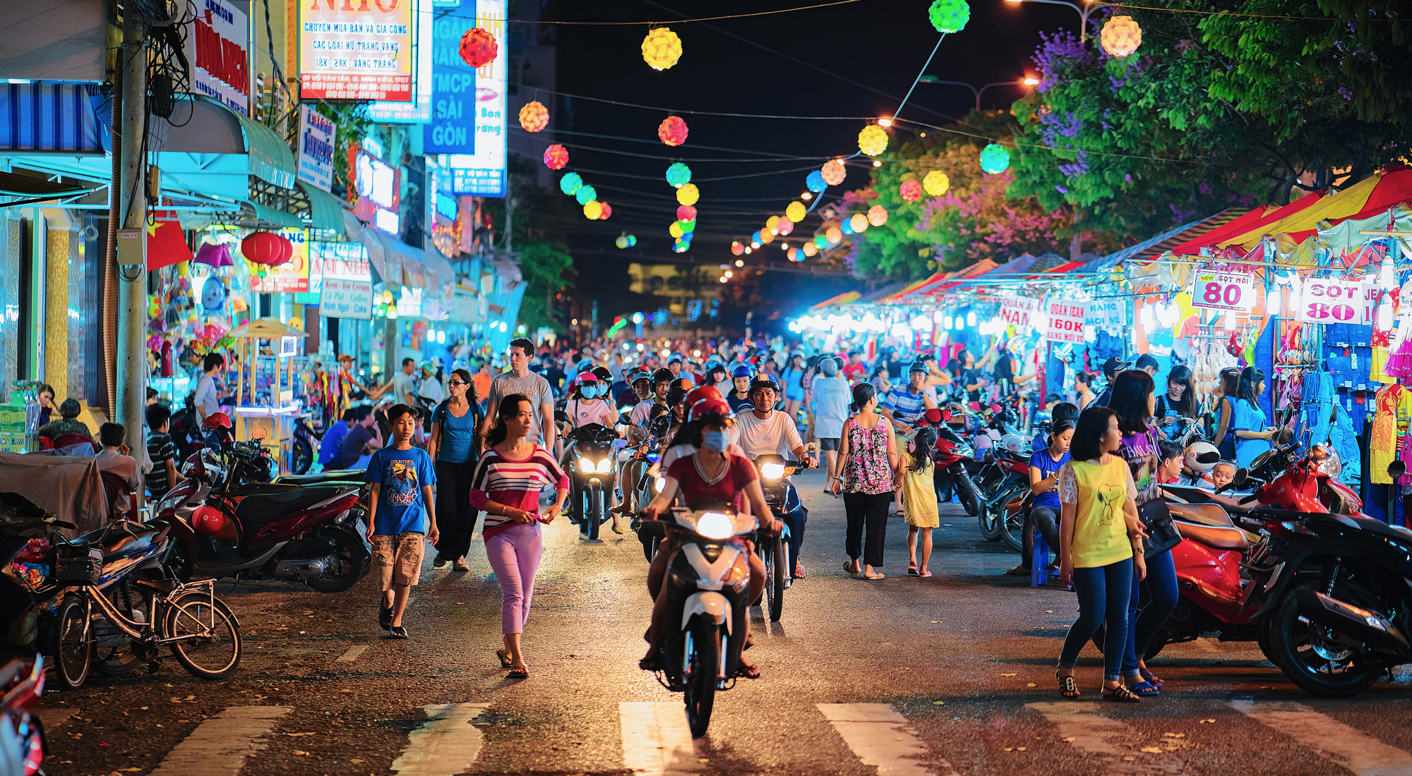 People on the street market in Can Tho, Vietnam, at night. Blurred focus.