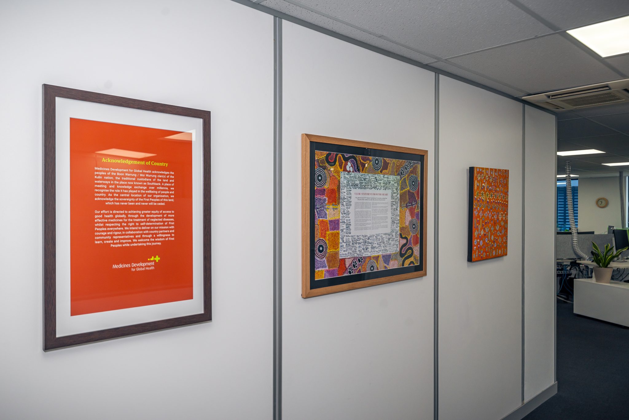 Acknowledgement of Country poster, designed and printed by EDCo., displayed with the Uluru Statement and Bush Native Plants painting in MDGH’s office entrance.