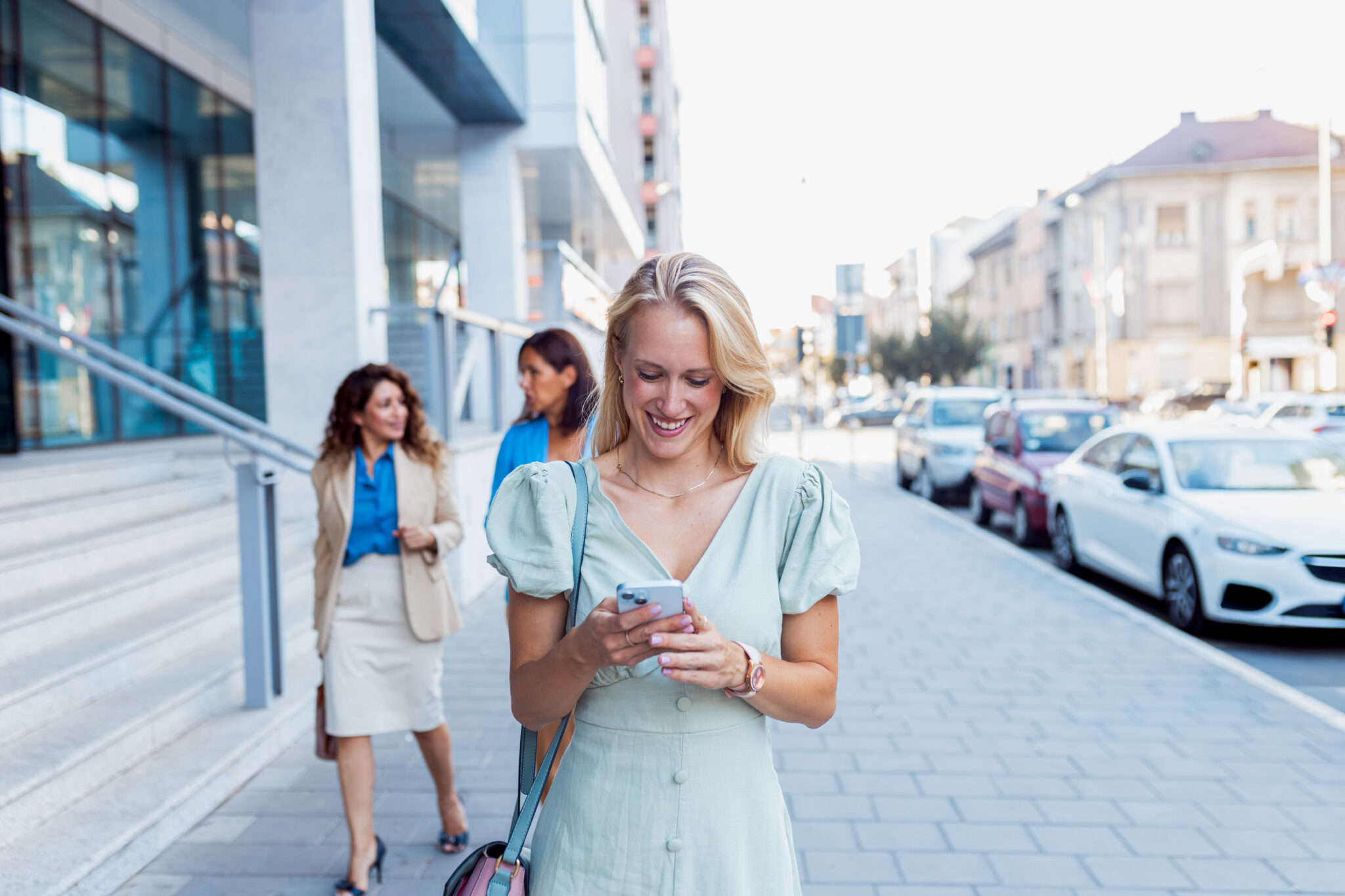 Businesswomen walking outside a modern office, representing work-life balance and more flexible working hours